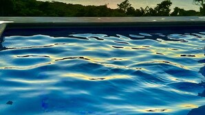 Une piscine avec vue sur le coucher de soleil.