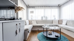 Een moderne woonkamer met een bank, een glazen salontafel en een kast.