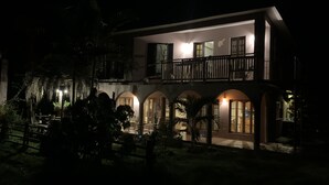 Un edificio de dos pisos con balcón y ventanas arqueadas.