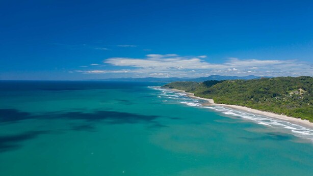 A coastal landscape with a beach and forested hills. - Villa Koi - Modern and Sophisticated Villa close to the Beach (Santa Teresa beach)