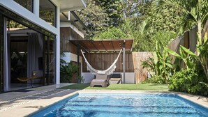 A swimming pool with a wooden deck and a hammock. - Villa Koi - Modern and Sophisticated Villa close to the Beach (Santa Teresa beach)