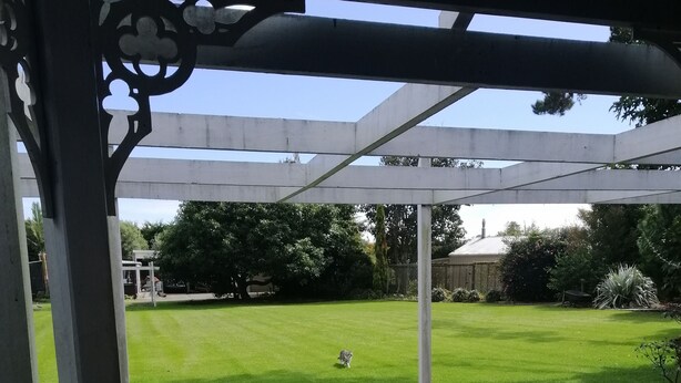 A covered patio area with a view of a grassy yard. - Spacious Garden Cottage w/ woodburner (Waitara)
