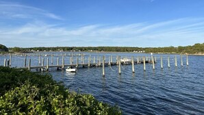 A pier extending into calm water with a clear sky above. - The beach is waiting. (East Lyme)