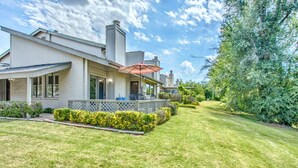 Une maison moderne à deux étages, dotée d’un porche abrité et d’une pelouse bien entretenue.
