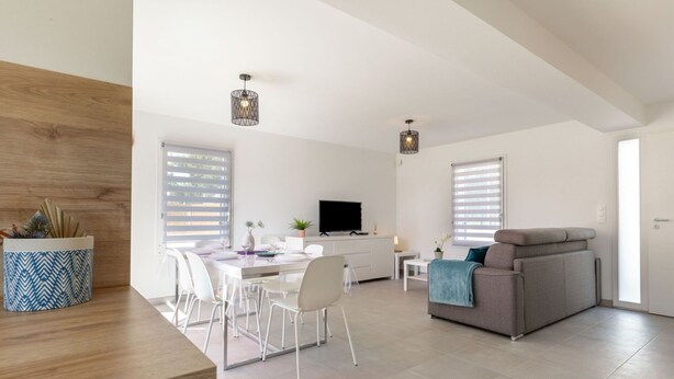 A spacious living area with a dining table, sofa, and TV. - Beautiful  villa for 6 people with WIFI, TV, terrace and pets allowed (Royan)