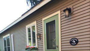 Una casa con una porta verde, una cassetta delle lettere e un cartello che recita 'Parson's Pride'.