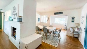 A modern living room with a fireplace, dining area, and kitchen. - Backyard Oasis, Htd Pool/Hot Tub, Beaches, No Fees (Sarasota)