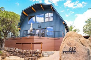Un grand bâtiment en bois bleu, doté d’un balcon, avec un mur de pierre à l’avant et un gros rocher sur lequel est gravée l’inscription « 812 W ROSER ST ».