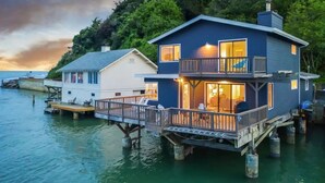 A waterfront house with a balcony and deck, connected to a dock. - Bolinas Beach Home - Over the water with spectacular views (Bolinas)