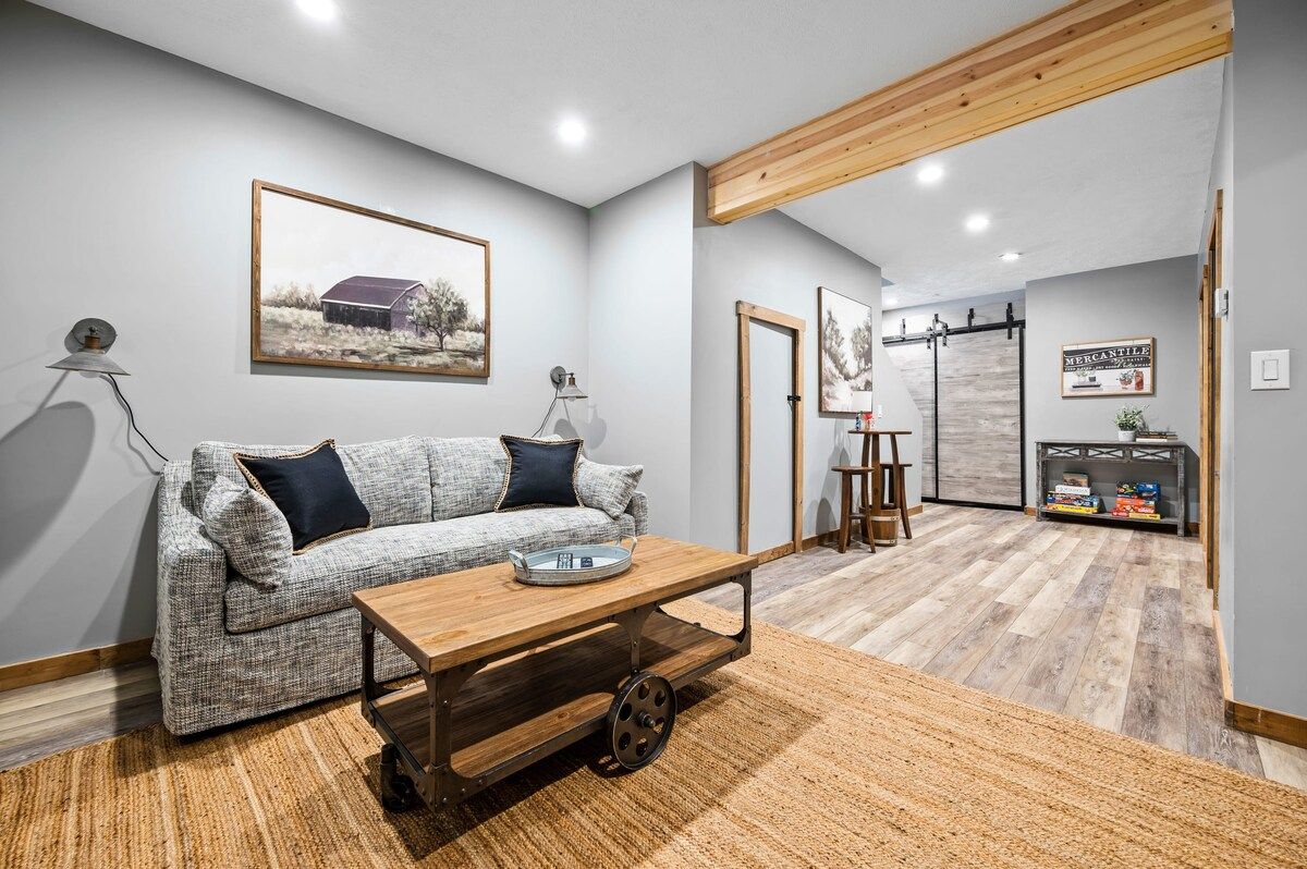 Una sala de estar moderna con un sofá, una mesa de centro de madera y una alfombra.