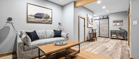 Una sala de estar moderna con un sofá, una mesa de centro de madera y una alfombra.