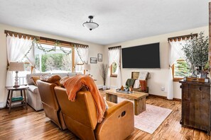 Ein gemütliches Wohnzimmer mit einer Ledersofa, einem Flachbildfernseher und einem Couchtisch aus Holz.