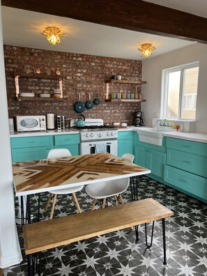 fun, bright cheery kitchen stocked with cooking ware and plates, glasses etc.