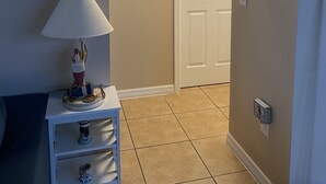 A hallway with a lamp, a painting, and a door. - Cozy, Clean, Convenient With A Beach Feel (Cape Coral)