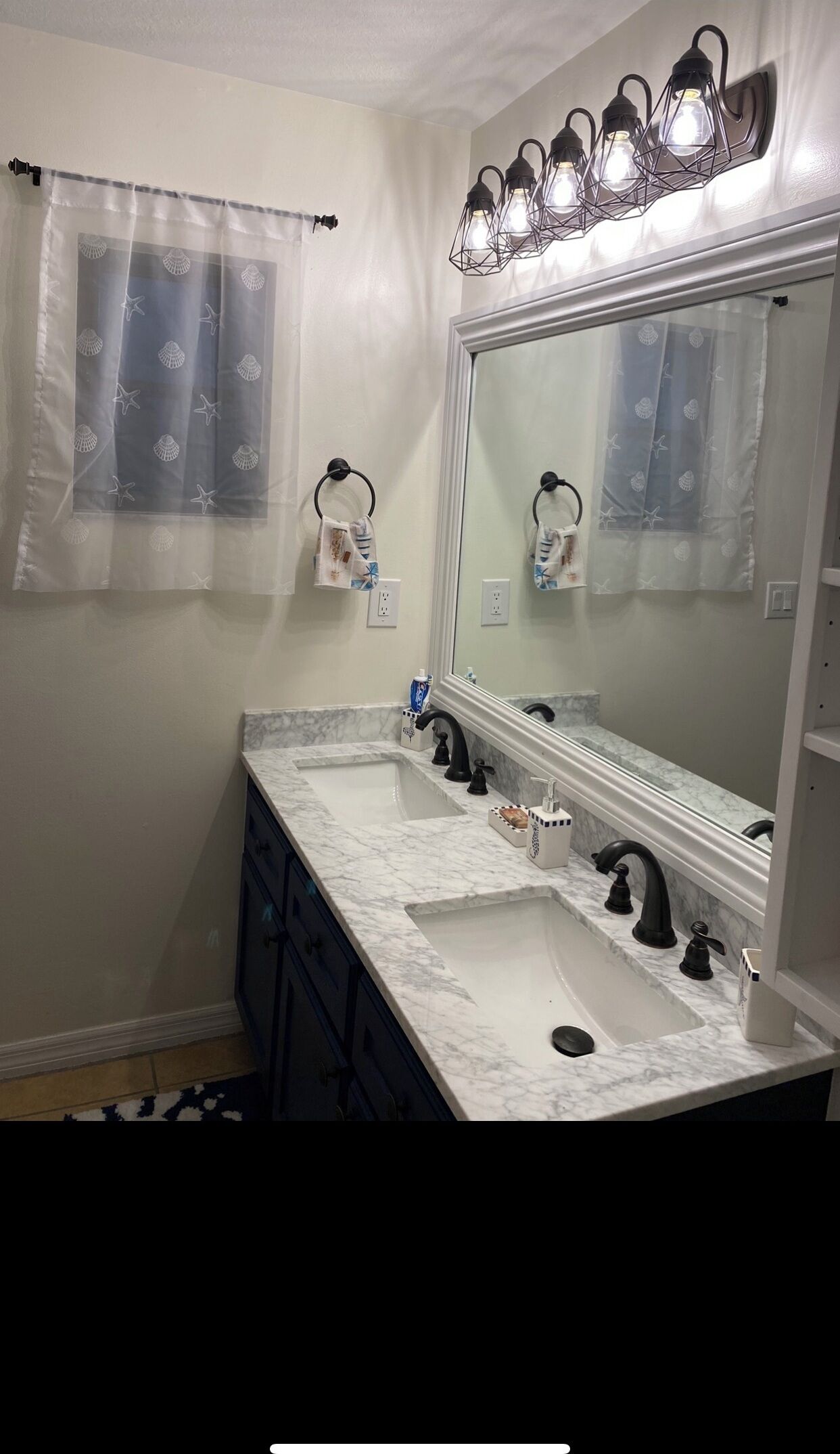 A bathroom with a double sink, a large mirror, and a ceiling light fixture.