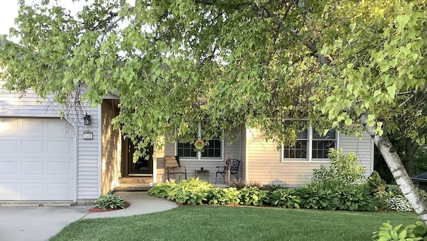 A two-story house with a front porch, a garage, and a well-maintained lawn. - The Farmhouse- country charm, room for family visiting, relaxing, or gathering  (West Union)