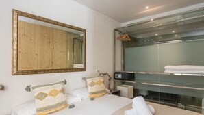 Une chambre d’hôtel moderne dotée d’un grand lit, d’un miroir à cadre en bois, d’une douche en verre et d’un panneau de commande.