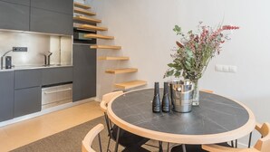 A modern kitchen with grey cabinets, a built-in oven, and a wooden staircase. - My Space Barcelona apartment with large terrace close to Barraquer clinic (Barcelona)