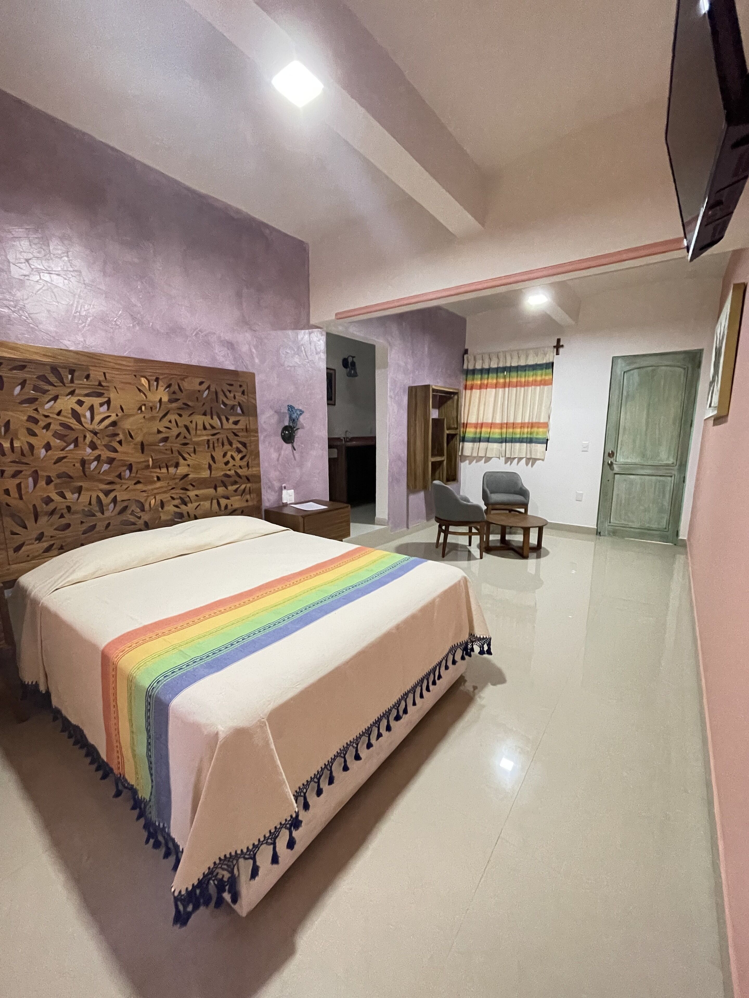 Un dormitorio con cama, mesita de noche y un pequeño escritorio con silla.