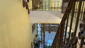 Un escalier avec une rampe métallique menant à un balcon situé au deuxième étage.