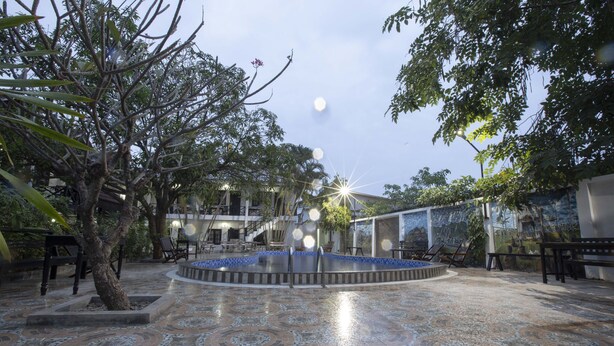 A courtyard with a fountain, tiled flooring, and surrounding trees. - Vientiane Garden Villa Hotel (Vientiane)