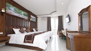 A hotel room with a large bed, a desk, a mirror, and a television. - Vientiane Garden Villa Hotel (Vientiane)
