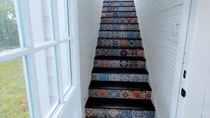 Una escalera con baldosas de colores que lleva a una plataforma.