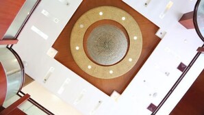 A modern interior with a circular central design, white walls, and wooden accents. - Haining Haodu Holiday Inn (Haining)