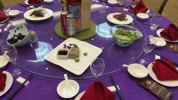 A round table set with plates, bowls, and glasses, indicating a dining arrangement.