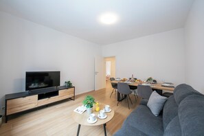 Relax in this stylish living space with a flat-screen TV, comfortable sofa, and dining area.