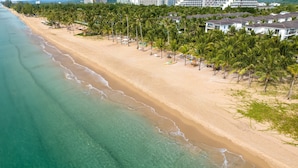 An aerial view of a beach with a row of palm trees and beachfront villas. - Andochine Resort & Spa Phu Quoc (Phu Quoc)