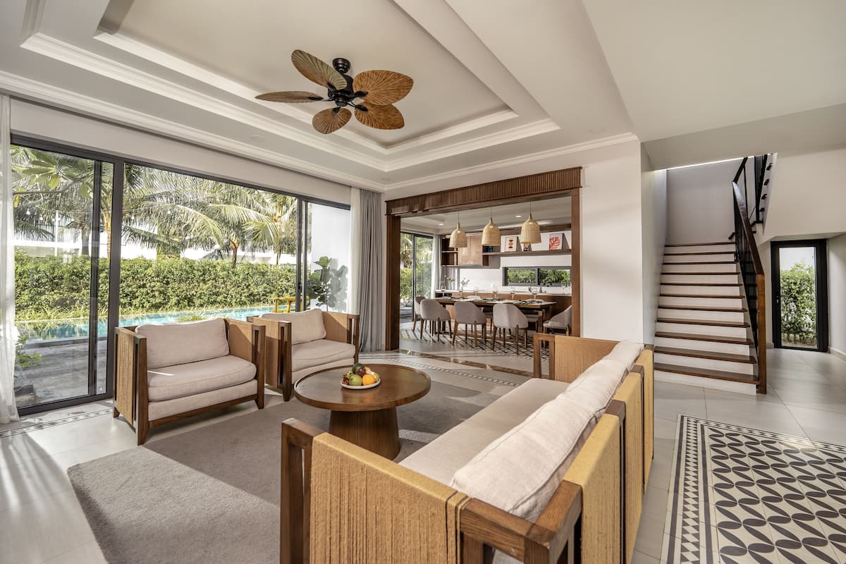 A spacious living area with a sofa, coffee table, and a ceiling fan.