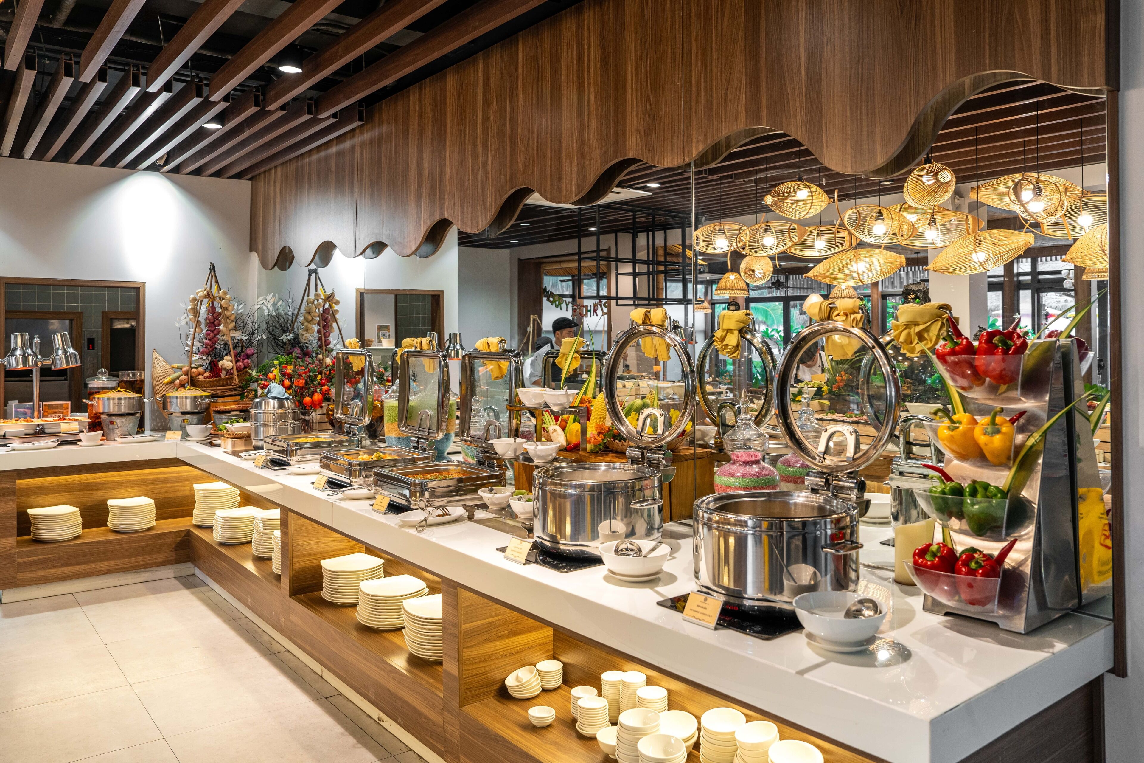 A buffet area with various food stations, including a salad bar, a hot dish station, and a fruit display.
