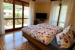 Une chambre à coucher avec un lit, une télévision et une vue sur l’extérieur.