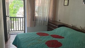 A bedroom with a bed, a dresser, a door leading to a balcony, and a ceiling light. - Mont Blanc, Amazing View From Private Terrace (Cogne)