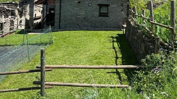 A stone house with a sloped roof, a small front porch, and a fenced yard. - Mont Blanc, Amazing View From Private Terrace (Cogne)