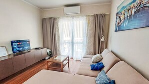 A living room with a sofa, a TV, and a painting on the wall. - Vacation home Ante by Interhome (Brodarica)
