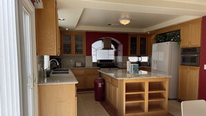 Une cuisine moderne avec des meubles en bois, un plan de travail en marbre et un four encastré.