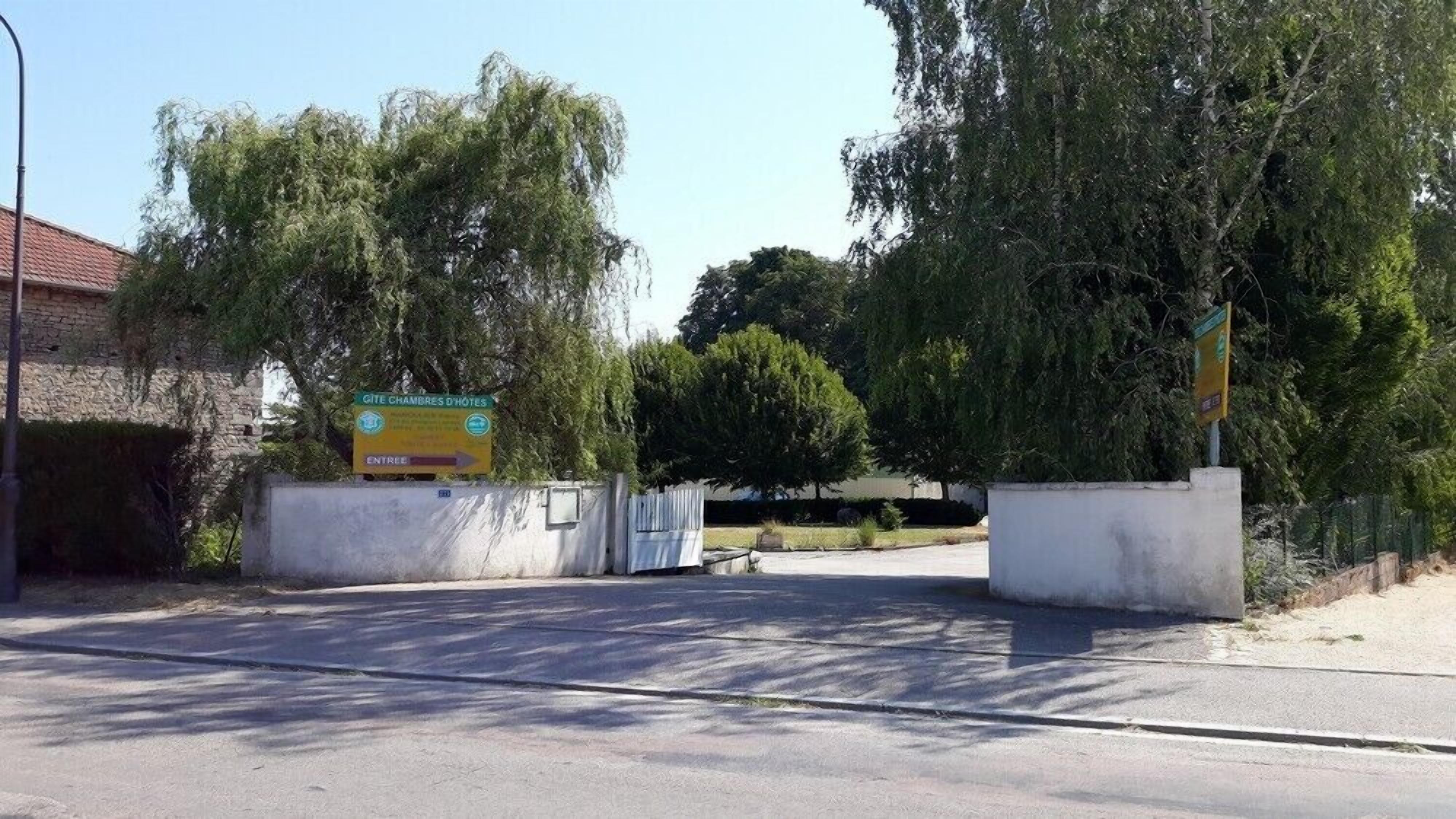 A hotel entrance with a sign indicating 'Gîte Chambres D'Hotes' and an arrow pointing to the entrance.