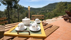 A picnic setup with a tray of white cups and a teapot on a checkered tablecloth, overlooking a mountainous landscape. - Nature & Tranquility only 25km from Barcelona (Torrelles de Llobregat)