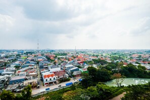 A residential area with houses, a river, and a distant tower. - Scenic 1Br Apartment At Mustika Golf Residence (Cikarang)
