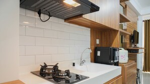 Una cocina moderna con estufa a gas, encimera blanca, armarios de madera y horno integrado.