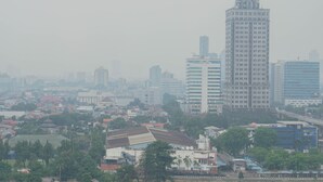 Un paisaje urbano con un rascacielos destacado, edificios más pequeños alrededor y una mezcla de construcciones residenciales y comerciales.