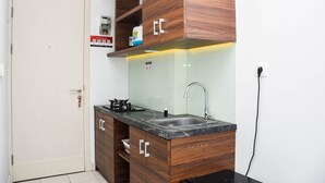 Una cucina compatta con mobili in legno, un lavello in acciaio inossidabile e un piano di lavoro.
