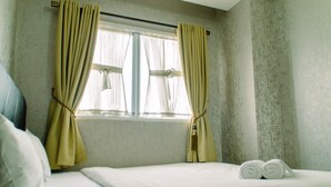A hotel room with a bed, curtains, and a window. - Minimalist And Comfort Living 2Br At Signature Park Grande Apartment (Jakarta)