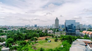 A cityscape with a mix of modern and traditional buildings, a large open park area, and a clear sky. - Minimalist And Comfort Living 2Br At Signature Park Grande Apartment (Jakarta)