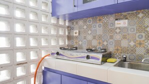 A kitchen with a gas stove, a sink, and a patterned backsplash. - Comfort Living Studio At Margonda Residence 1 Apartment (Depok)