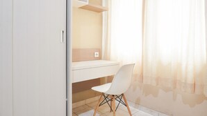 A room with a desk, chair, and shelves. - Comfort Living Studio At Margonda Residence 1 Apartment (Depok)