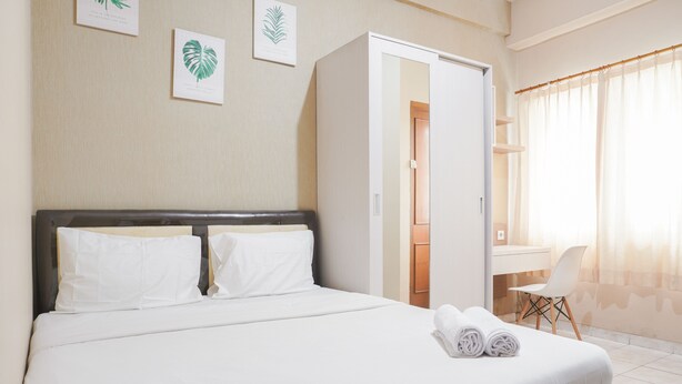 A hotel room with a bed, a desk, and a chair. - Comfort Living Studio At Margonda Residence 1 Apartment (Depok)