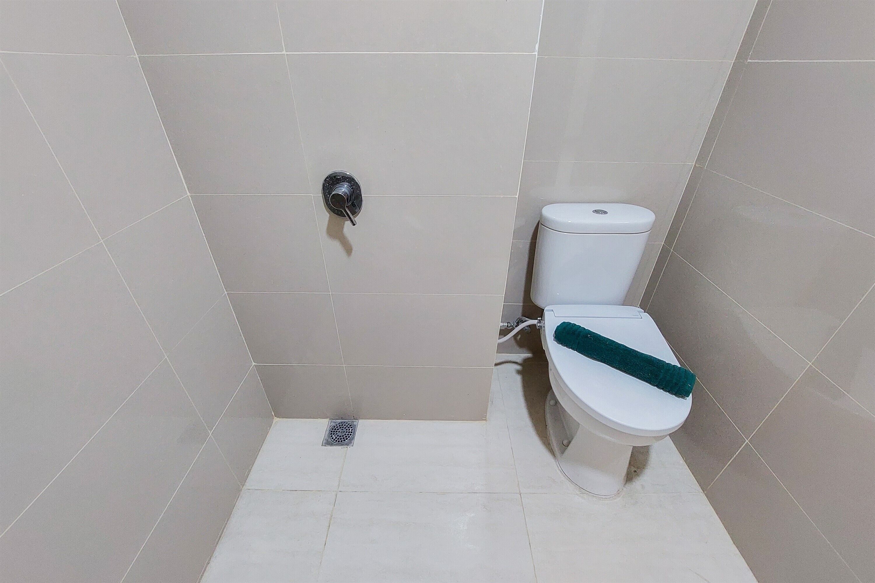 Une salle de bain équipée de toilettes, d’une douche et d’un drain.
